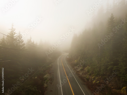 Aerial view of a scenic road during a foggy and sunny day. Located on the West Coast of Vancouver Island near Tofino and Ucluelet, British Columbia, Canada.