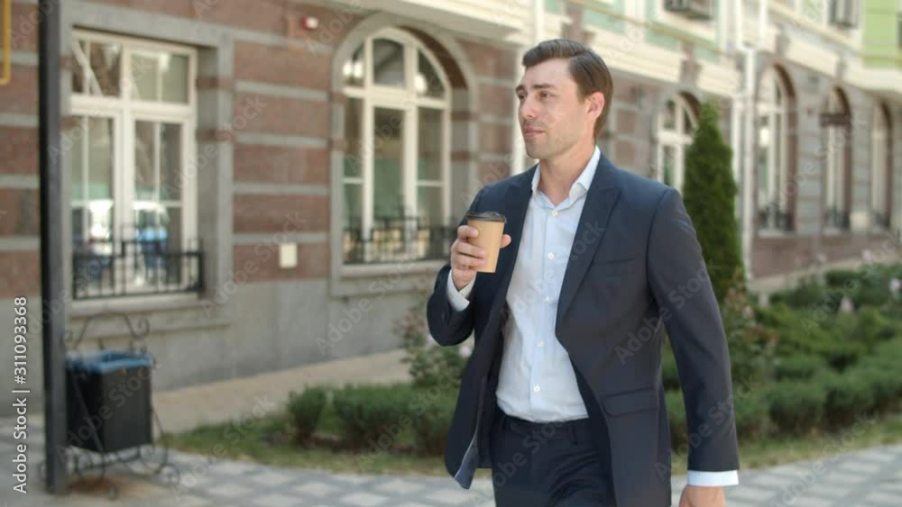 Closeup man drinking hot coffee outdoor. Businessman walking with hot of coffee Closeup man drinking hot coffee outdoor. Businessman walking with hot of coffee