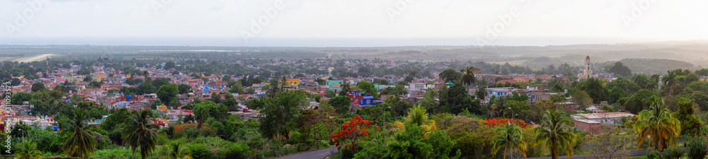 Aerial Panoramic view of a small touristic Cuban Town during a colorful and cloudy sunset. Taken in Trinidad, Cuba.