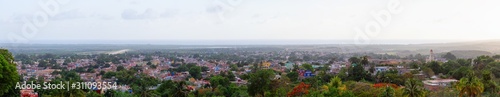 Aerial Panoramic view of a small touristic Cuban Town during a colorful and cloudy sunset. Taken in Trinidad, Cuba.