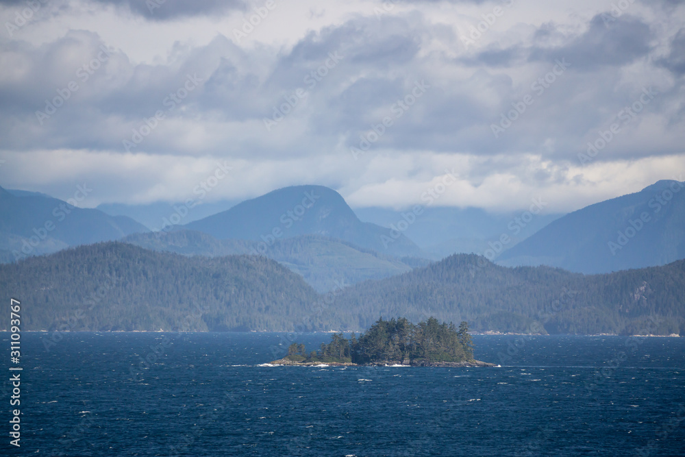 Northern Vancouver Island, British Columbia, Canada. Rocky Islands on the Pacific Ocean during a sunny and cloudy day with Islands and the Mainland in the background.