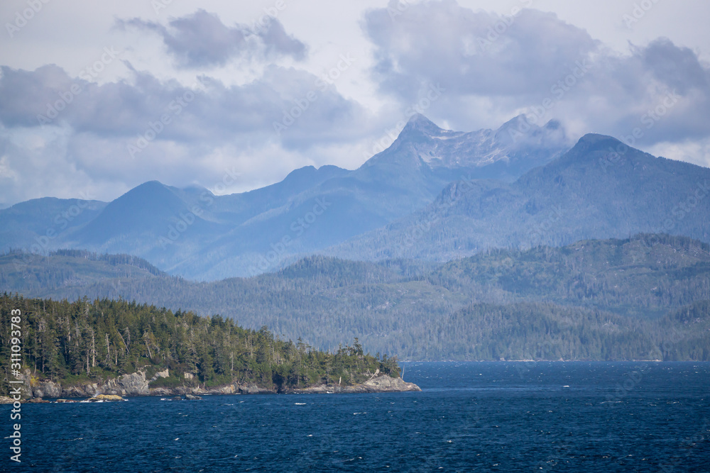 Northern Vancouver Island, British Columbia, Canada. Rocky Islands on the Pacific Ocean during a sunny and cloudy day with Islands and the Mainland in the background.