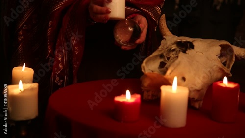 A woman holds a candle to perform magical rituals. The witch casts a spell. The concept of magic and witchcraft