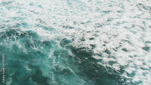 Small waves rolling near a volcanic beach on Tenerife, Canary Islands, aerial view from above