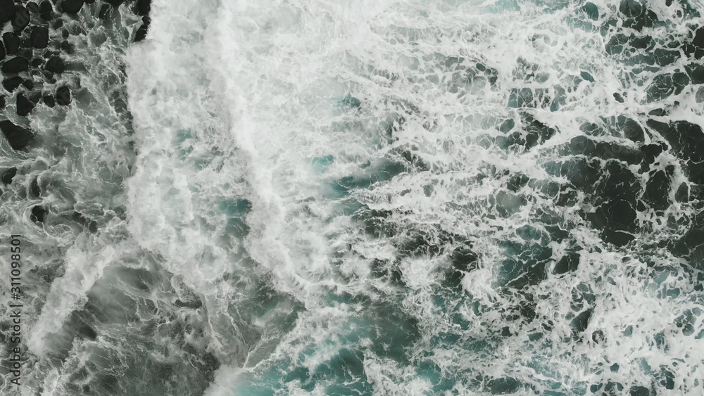 Aerial view. Very beautiful view of the Atlantic coast, aquamarine color of the waves falling on the beach of volcanic origin, Tenerife, Spain