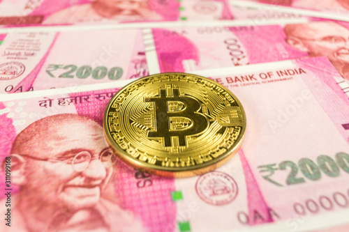 Cryptocurrency gold Bitcoin coin on a Indian rupee