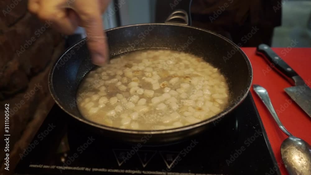 frying onions and ingredients in a frying pan frying onions and ingredients in a frying pan