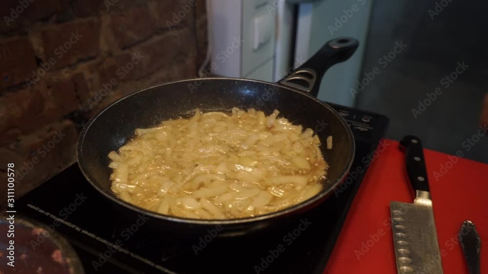 frying onions and ingredients in a frying pan frying onions and ingredients in a frying pan