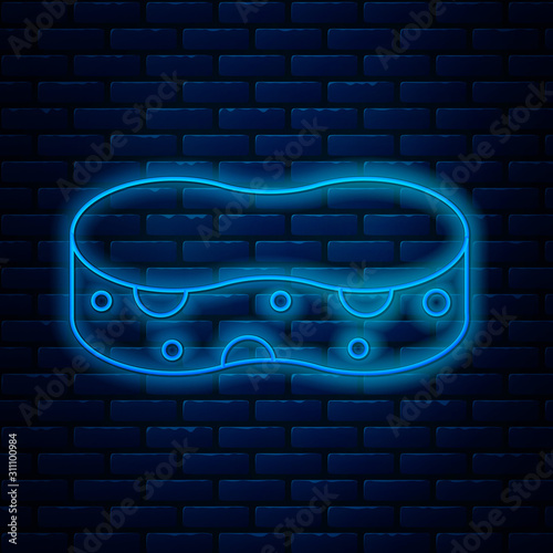 Glowing neon line Sponge icon isolated on brick wall background. Wisp of bast for washing dishes. Cleaning service concept. Vector Illustration