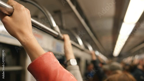 girl hand wearing orange leather jacket holds metro handrail photo