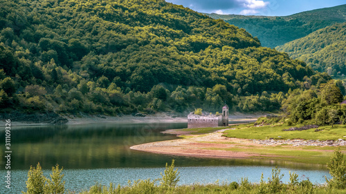 Obraz na płótnie Landscape side view of old church of St Nicholas. Usually partially submerged in Lake. Spring in National Park Mavrovo, North Macedonia. w salonie