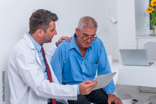 A doctor is talking to senior (old) patient in the office and explain's to him his diagnosis.