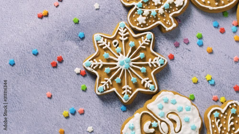 Close up of sweet gingerbread cookies with colored sprinkles on grey texture surface. Christmas holiday homemade cookies. 4k. Top view. Close up of sweet gingerbread cookies with colored sprinkles on grey texture surface. Christmas holiday homemade cookies. 4k. Top view.