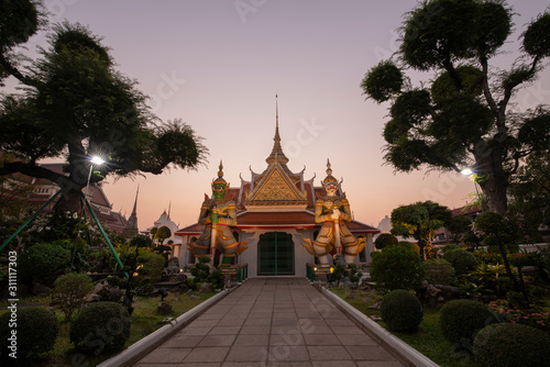 In front of the Giant Church at Arun Ratchawararam Temple in the evening sunset Considered to be a famous tourist attraction of Bangkok © aee_werawan