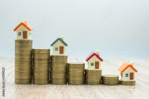 Coin pile and toy house, credit concept by house, money from coins, business, finance and money. Successful financial business concepts. Savings for real estate project with small model.