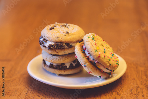 Chocolate chip and sugar cookie sandwich treats on a white plate