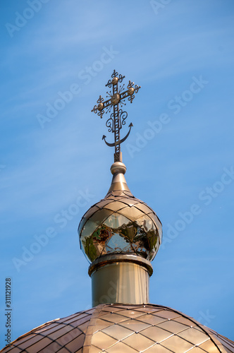 Golden cross on the dome of the Christian Cathedral against the blue sky