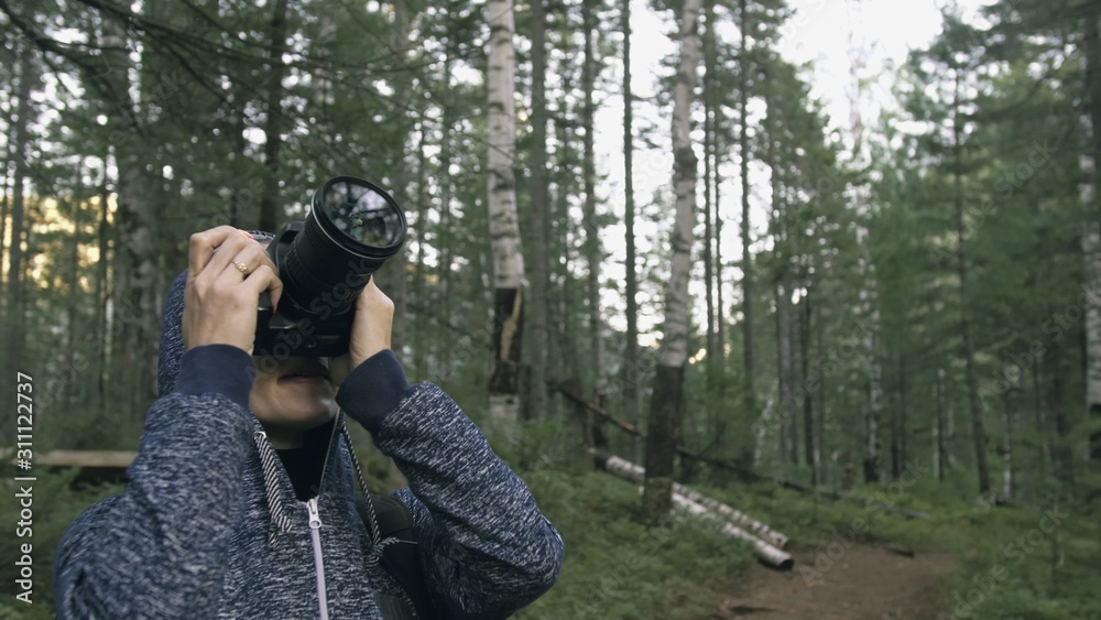 Traveler photographing scenic view in forest. One caucasian woman shooting nice magic look. Girl take photo video on dslr mirrorless camera. Professional photographer travel with backpack. Outdoor. Traveler photographing scenic view in forest. One caucasian woman shooting nice magic look. Girl take photo video on dslr mirrorless camera. Professional photographer travel with backpack. Outdoor.