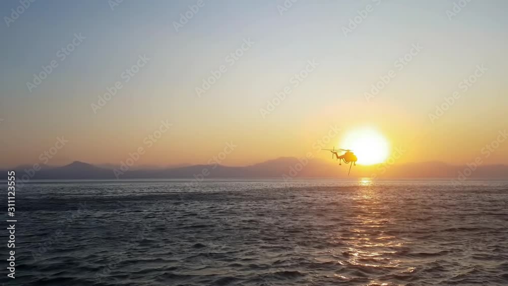 Fire helicopter against a dramatic sunset. Fire helicopter against a dramatic sunset.