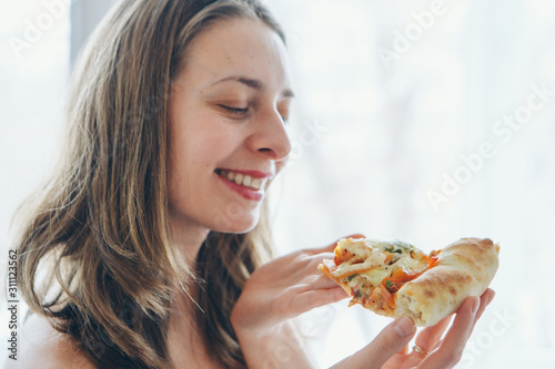 Portrait of a happy girl eating pizza. fast food advertising, pastry, cooking, overeating, diet, Italian food. Isolated on white background. Copy space