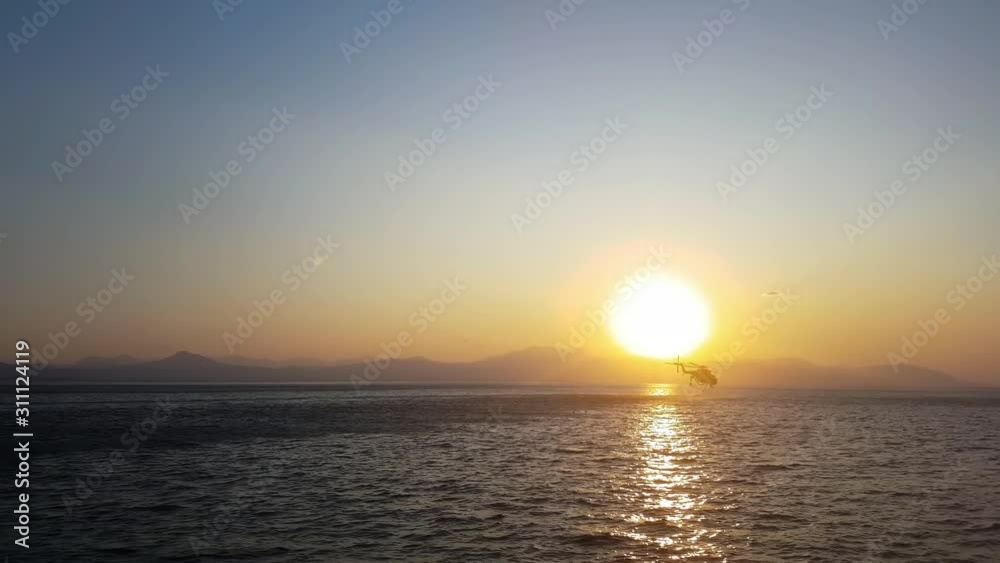 Fire helicopter against the sunset diving for water. Fire helicopter against the sunset diving for water.