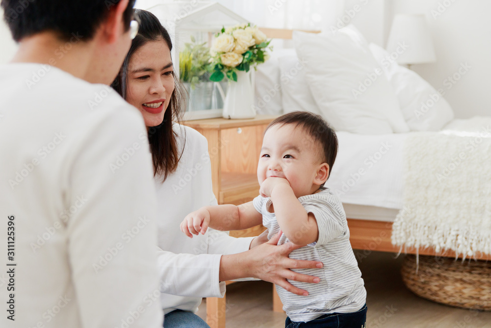 Asian parents play with baby in the bedroom. Happy Family Concept Asian parents play with baby in the bedroom. Happy Family Concept