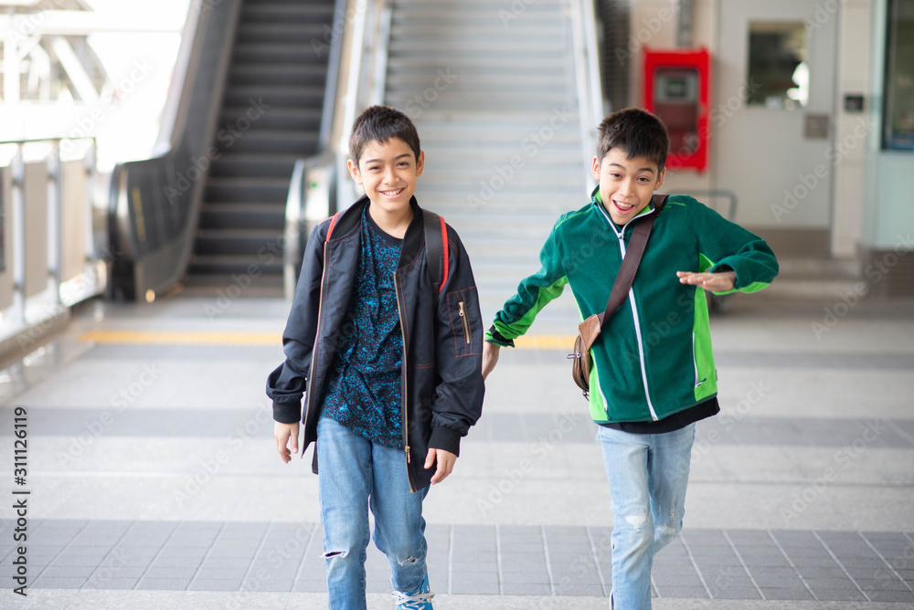 Obraz premium Little boy buying electric ticket and walking in the public sky train station with family