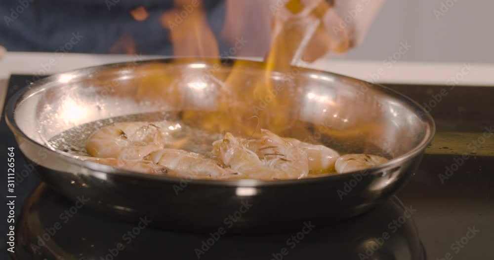Deep fried tiger shrimps preparing on frying pan. with flame at kitchen. tossing, mixing and throwing on pan, close-up. slow motion food Deep fried tiger shrimps preparing on frying pan. with flame at kitchen. tossing, mixing and throwing on pan, close-up. slow motion food