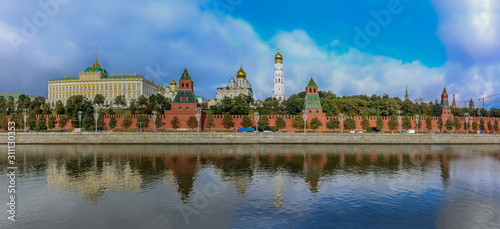 Panorama of the red Kremlin wall, tower and golden onion domes of cathedrals over the Moskva River in Moscow, Russia