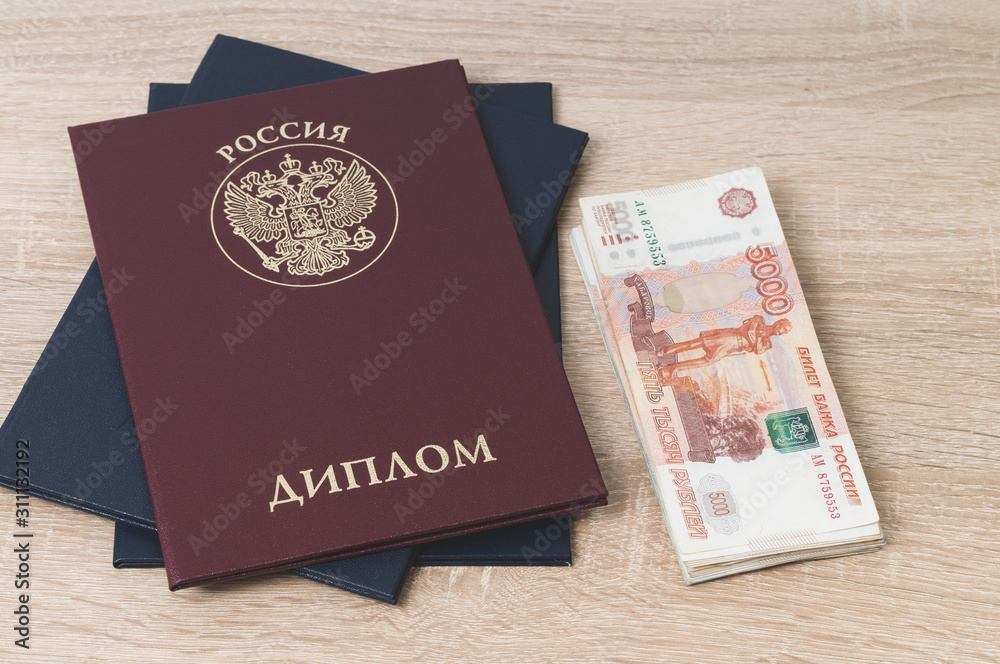 diploma of higher education of Russia on the table and cash notes, inscription in Russian, translation: diploma of higher education of Russia on the table and cash notes, inscription in Russian, translation: