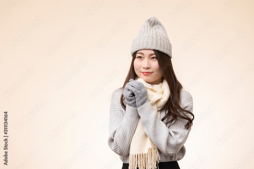 ベージュを背景にした冬服を着た若い女性のポートレート ベージュを背景にした冬服を着た若い女性のポートレート