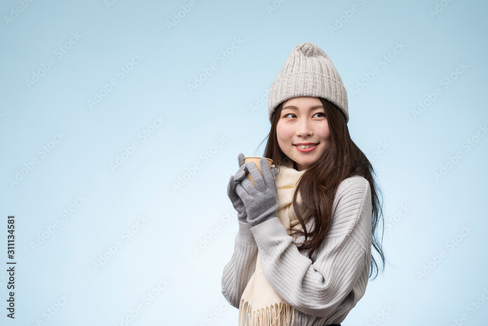 水色を背景にした冬服を着た若い女性のポートレート 水色を背景にした冬服を着た若い女性のポートレート