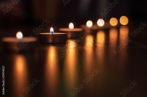 A row of candles on a dark background.