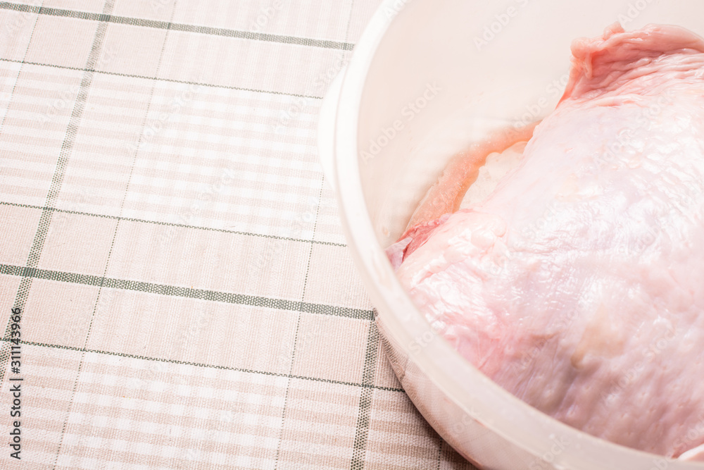Boneless raw turkey fillet in plastic egg on kitchen table. Boneless raw turkey fillet in plastic egg on kitchen table.