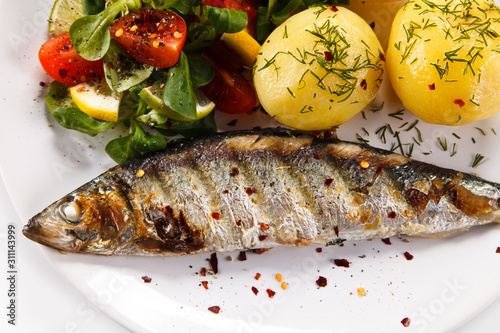 Fish dish - grilled herring with vegetables on white background