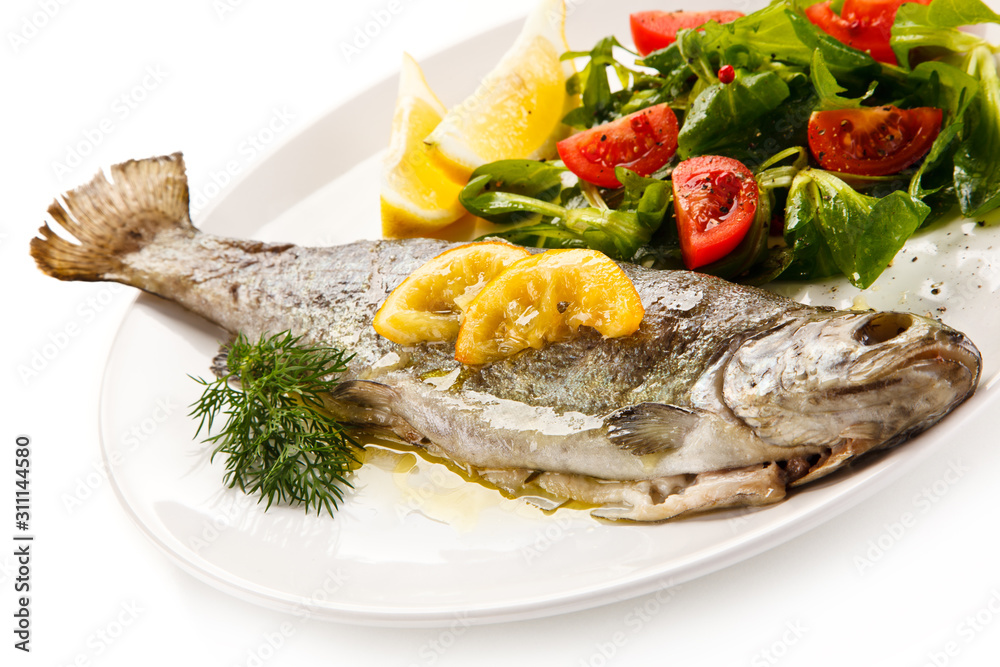 Fish dish - roasted trout with vegetables on white background Fish dish - roasted trout with vegetables on white background