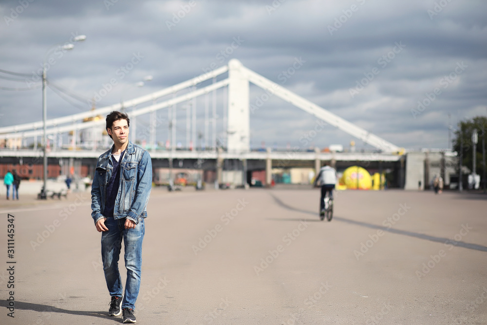 A young man walks in the park at lunch time. A man is on a walk in the city. A student in the park. A young man walks in the park at lunch time. A man is on a walk in the city. A student in the park.