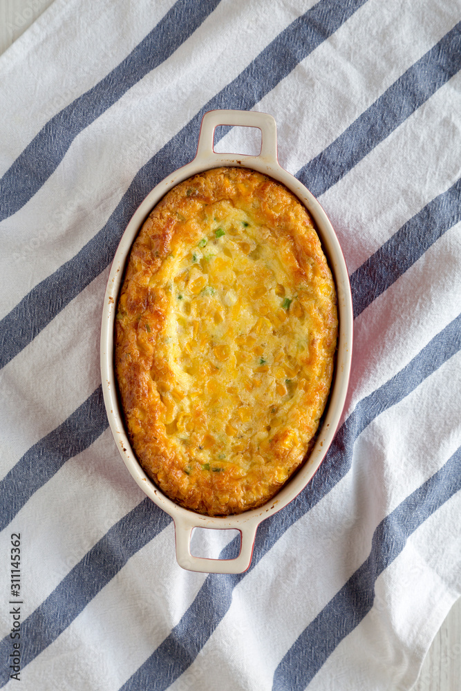 Homemade Cheddar Corn Pudding Casserole on cloth, view from above. Flat lay, top view, overhead. Homemade Cheddar Corn Pudding Casserole on cloth, view from above. Flat lay, top view, overhead.