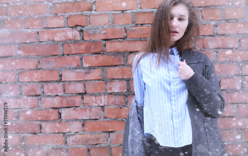 Young girl outdoors in winter. Model girl posing outdoors on a winter day. A festive weekend in the street walking girl.