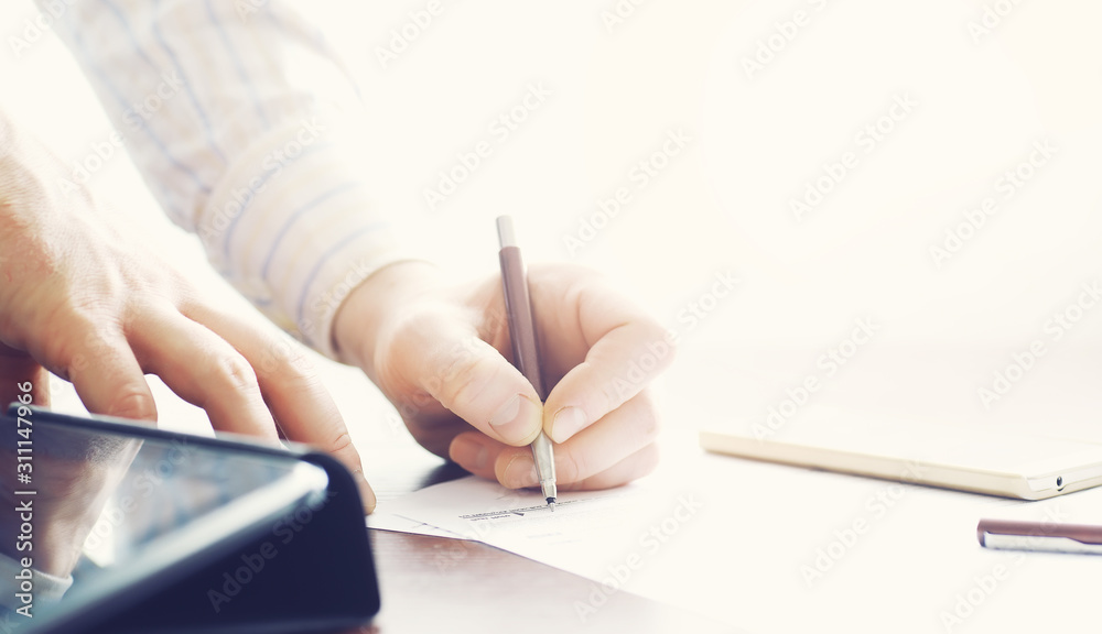 Business meeting. A man signs a contract. Male hand with pen makes notes in the office. Business meeting. A man signs a contract. Male hand with pen makes notes in the office.