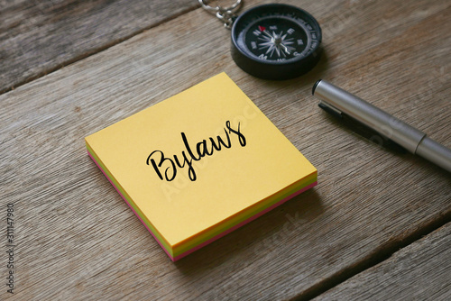Canvas Print Compass,pen and yellow sticky notes written with Bylaws on wooden background