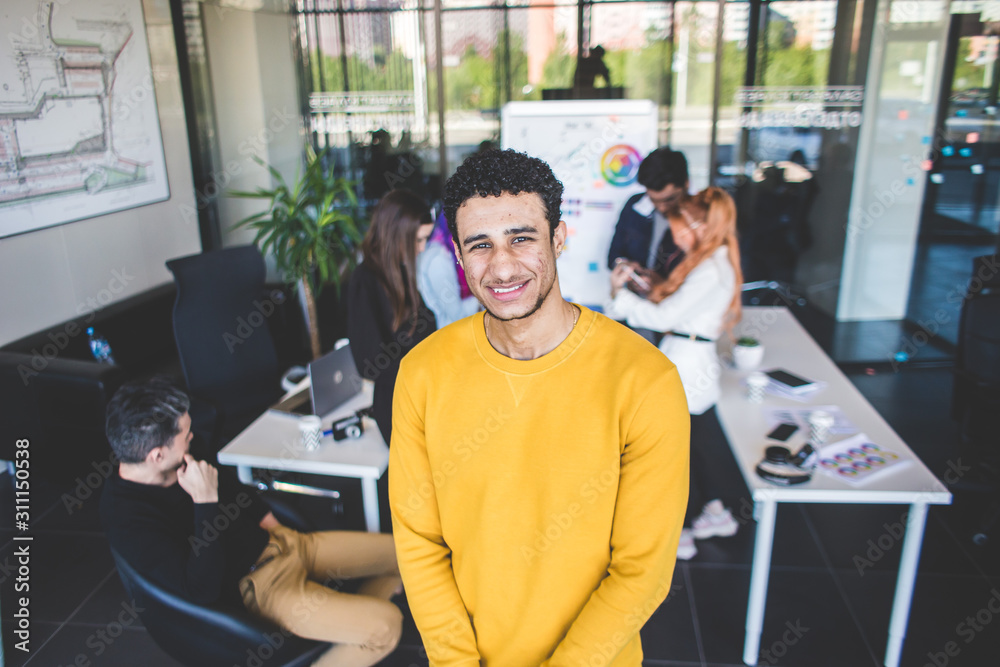 Fototapeta premium Group of multi ethnic executives discussing during a meeting. Business man and woman sitting around table at office and smiling. A team of young creative designers