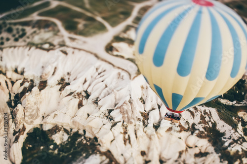 Hot air balloon flying over rock landscape at Cappadocia Turkey. photo