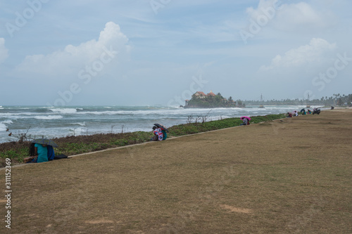 The sand beach and rocky shore of the Indian ocean, Ahungalla, Sri Lanka photo