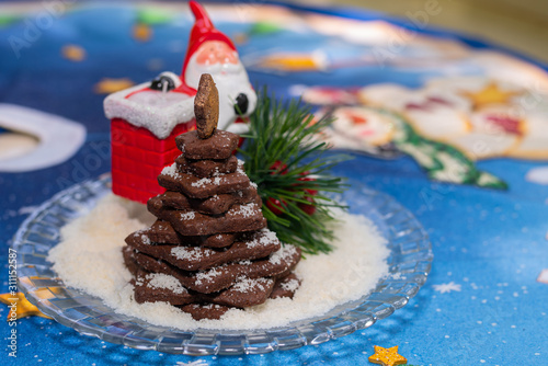 Stacked cocoa cookies christmas tree with colourful christmas background