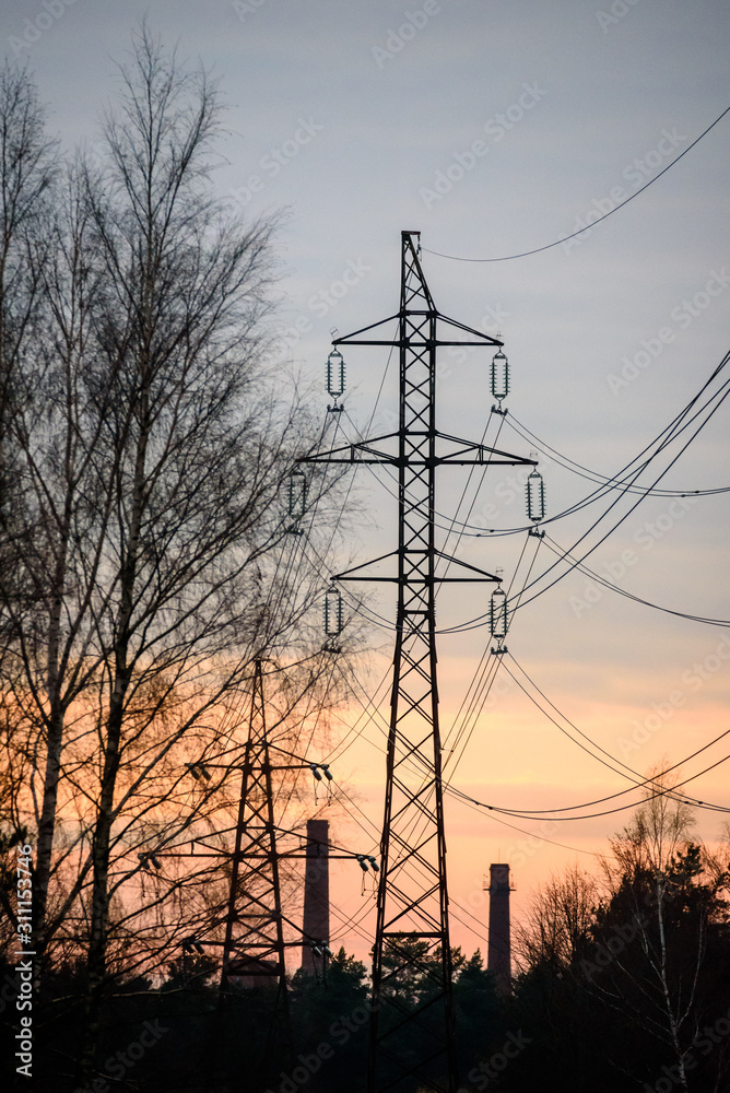 Fototapeta premium Selective focus photo. Beautiful view to powerful and huge high-voltage electricity poles, during sunset.