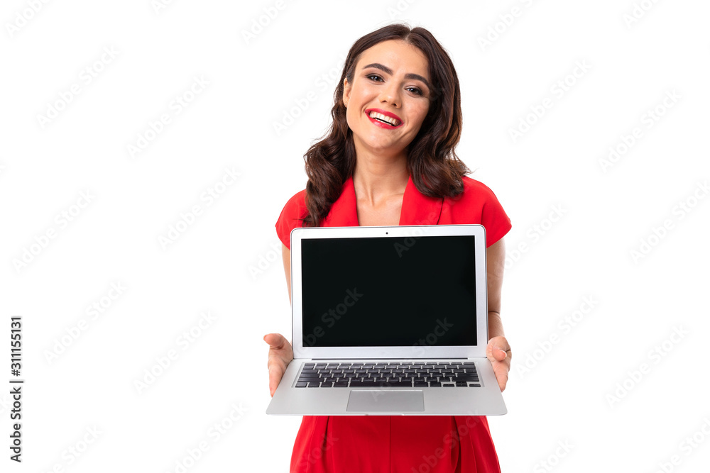 lovely brunette girl in red dress holding a laptop with mockup in her hands on a white studio wall. lovely brunette girl in red dress holding a laptop with mockup in her hands on a white studio wall.