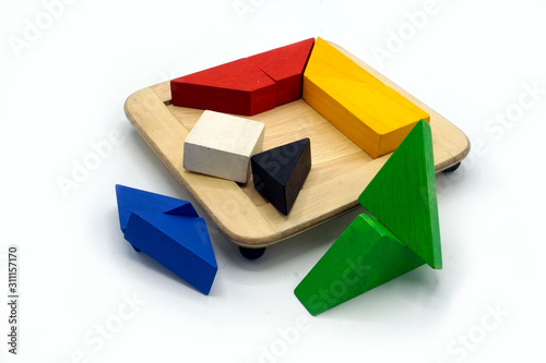 Tangram, Chinese traditional puzzle game made of different colorful wooden pieces that come together in a distinct shape, in a wooden box.