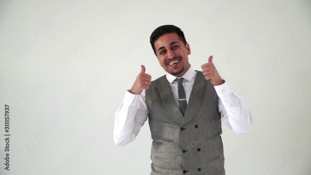 The Oriental man gives a thumbs up. Man dressed in office clothes shirt and tie The Oriental man gives a thumbs up. Man dressed in office clothes shirt and tie