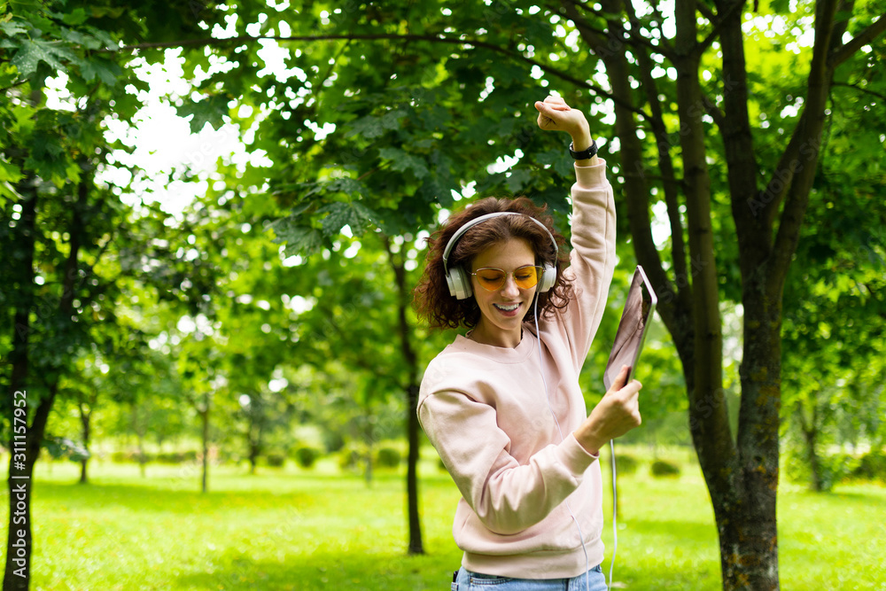 girl meditates to music in a summer park girl meditates to music in a summer park